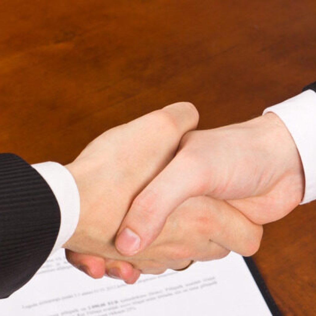 Businessmen hand shake after signing the agreement.